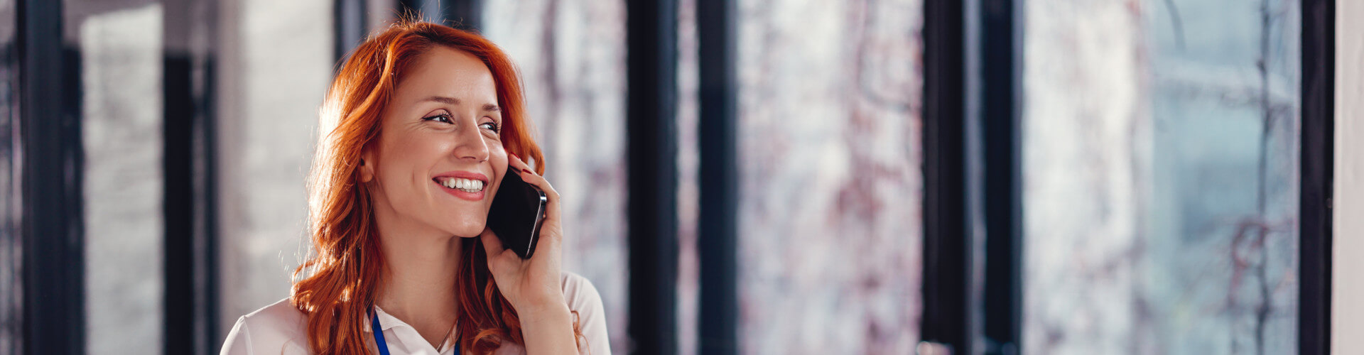 Woman talking on a mobile phone in an office.